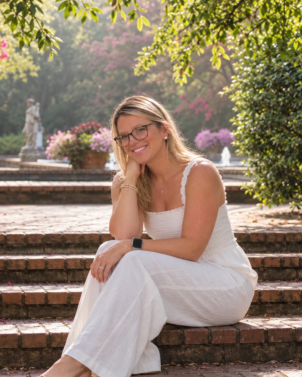 Ashley Smith Lucas, founder and owner of Magnolia Grace & Co., LLC, seated on brick garden steps in Aiken, South Carolina